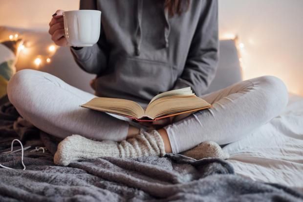 look comfy na cama com café e livro